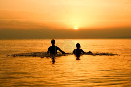 couple heureux dans la mer sur la silhouette Voyage nature