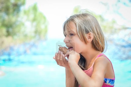 Téléchargez les photos : Joyeux enfant fille avec de la crème glacée au bord de la mer dans la nature dans le voyage du parc - en image libre de droit
