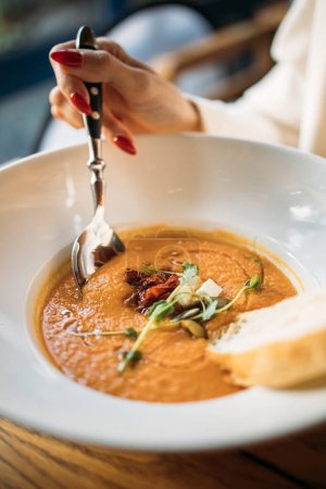 Téléchargez les photos : Une personne mangeant de la soupe de tomates aux légumes au restaurant - en image libre de droit