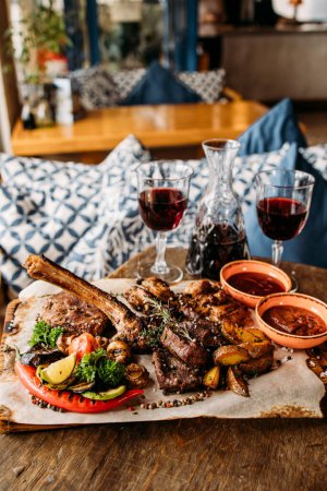 Photo for Meat and vegetables BBQ served with red house wine at the restaurant - Royalty Free Image