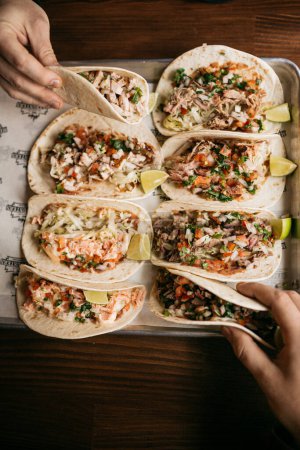Téléchargez les photos : Manger une variété de tacos avec du poulet et du bœuf au restaurant - en image libre de droit