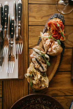 Téléchargez les photos : Ensemble de bruschetta avec poisson, viande et légumes servi sur la table du restaurant - en image libre de droit