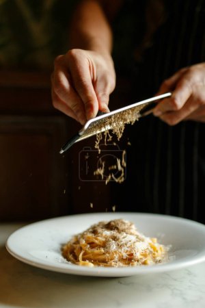 Téléchargez les photos : Mains d'homme mélangeant et mangeant des pâtes au restaurant - en image libre de droit