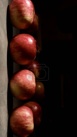 Téléchargez les photos : Des pommes rouges. Pommes colorées en gros plan sur un fond sombre. Photographie d'art. - en image libre de droit
