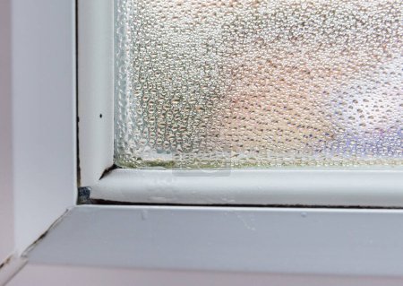 Photo for Condensation gathers in the corner of a double glazed window after cold night which can cause mold and health issues - Royalty Free Image