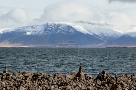 paisaje de apilamiento de piedra en la costa con montaña de nieve en Islandia 