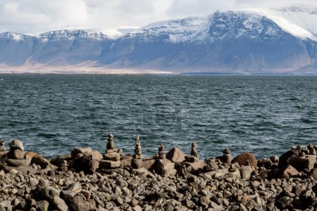 paysage de pierre empilable sur la côte avec montagne de neige en Islande