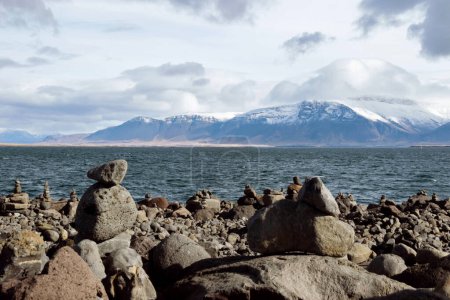 paysage de pierre empilable sur la côte avec montagne de neige en Islande 