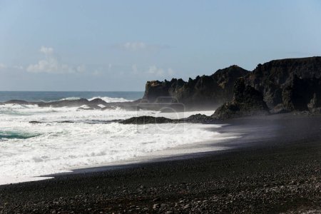 Wellen an Land an der Südküste, schwarzer Strand in Island