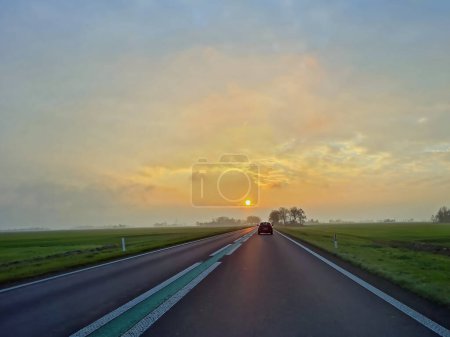 Photo for Driving at sunset in the countryside from Friesland in the Netherlands - Royalty Free Image