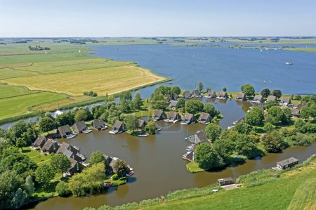 Photo for Aerial from typical dutch landscape: Houses and boats at the lake in the countryside from Friesland in the Netherlands - Royalty Free Image