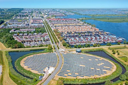 Foto de Granja de paneles solares con un diseño único en una forma de isla (Zoneiland). La energía se utiliza para alimentar la calefacción urbana (stadswarmte) en un distrito sostenible moderno Noorderplassen en Almere, Países Bajos. - Imagen libre de derechos