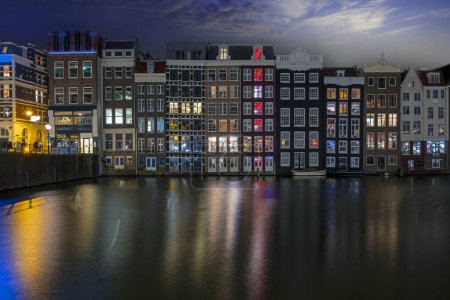 Photo for Traditonal houses at the Damrak in Amsterdam in the Netherlands by night - Royalty Free Image