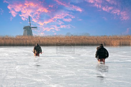 Foto de Hielo en trineo en un invierno frío en el molino de viento en los Países Bajos al atardecer - Imagen libre de derechos