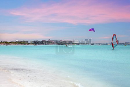 Téléchargez les photos : Sports nautiques sur la mer des Caraïbes à Palm Beach à Aruba au coucher du soleil - en image libre de droit