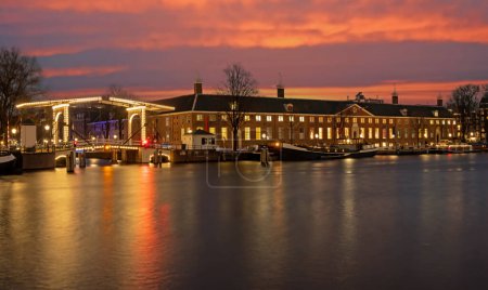 Téléchargez les photos : Paysage urbain d'Amsterdam à l'Amstel aux Pays-Bas au coucher du soleil - en image libre de droit