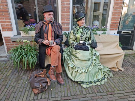 Foto de Deventer, Países Bajos, 16 de diciembre de 2023: Hermosa pareja en las calles de Deventer en coagulación de estilo victoriano durante el Dickens Festival. - Imagen libre de derechos