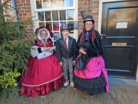 Photo for Deventer, Netherlands, December 16, 2023:Beautiful family in the streets of Deventer in victorian style cloting during the Dickens Festival. - Royalty Free Image