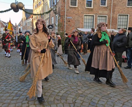 Foto de Deventer, Países Bajos, 16 de diciembre de 2023: Limpiadores y una orquesta de gaitas en las calles de Deventer en coagulación de estilo victoriano durante el Festival Dickens - Imagen libre de derechos