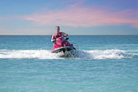Photo for Young guy cruising on the caribbean sea on a jet ski - Royalty Free Image