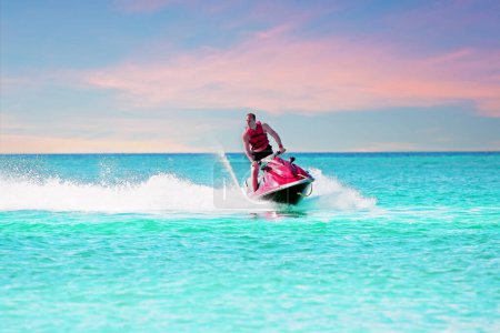 Photo for Young guy cruising on a jet ski on the caribbean sea - Royalty Free Image