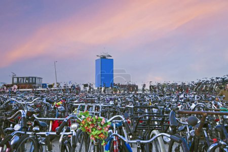 Téléchargez les photos : Stockage de vélos dans le port d'Amsterdam aux Pays-Bas au coucher du soleil - en image libre de droit