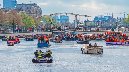 Foto de Ámsterdam, Países Bajos - 27 de abril de 2024: Los holandeses celebran el domingo en los canales de Ámsterdam en los Países Bajos - Imagen libre de derechos