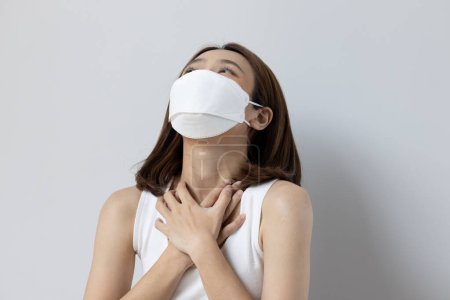 Photo for Ill woman wearing face mask with flu, sore throat, air pollution allergy or long covid sickness - Royalty Free Image