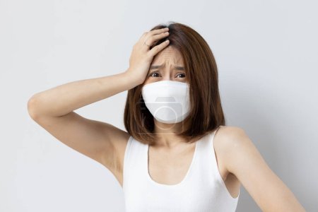 Photo for Frustrated woman still wearing mask and having headache fever or long covid symptom - Royalty Free Image