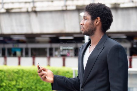 Téléchargez les photos : Homme d'affaires africain utilisant une application mobile smartphone - en image libre de droit