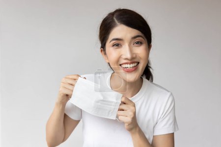 Photo for Happy smiling woman finally taking off face mask - Royalty Free Image