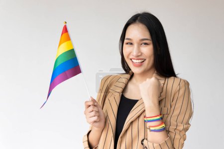 Téléchargez les photos : Forte personne LGBT non binaire renonçant drapeau arc-en-ciel pour le mois de la fierté de sensibilisation LGBT - en image libre de droit