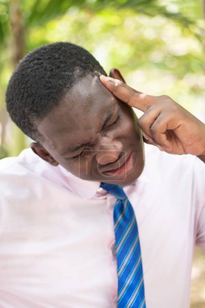 Photo for Ill African man office worker suffering from headache, health and sickness concept image for vertigo, dizziness, stress, depression, burnout, Alzheimer, brain cancer, memory loss, office syndrome - Royalty Free Image