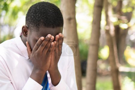 Téléchargez les photos : Un employé de bureau africain malade faisant face à la paume de la main, souffrant d'épuisement professionnel et de syndrome de bureau - en image libre de droit