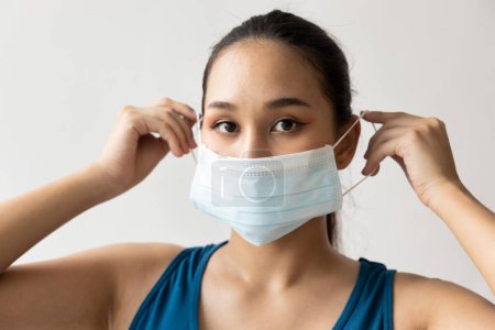 Téléchargez les photos : Femme portant un masque protecteur pour la protection contre la grippe saisonnière et la poussière - en image libre de droit