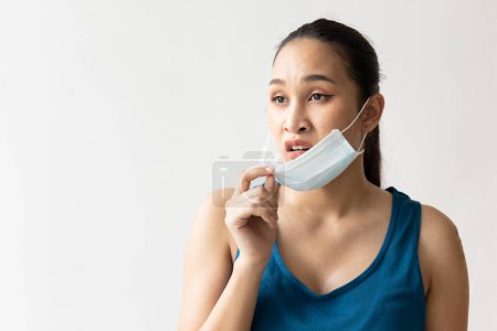 Photo for Frustrated woman taking off face mask - Royalty Free Image