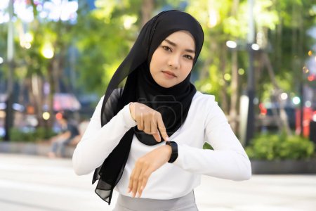 Téléchargez les photos : Malheureuse femme musulmane en attente de personnes non ponctuelles être en retard pour un rendez-vous - en image libre de droit