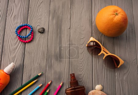 Photo for Artist pencils for inscription. accessories sunscreen spf care. sunglasses bracelets orange fruit pebbles. Summer background template mockup space colorful composition text. Top view wooden background - Royalty Free Image