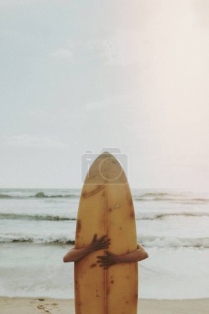 Photo for Surfer hugging a surfboard - Royalty Free Image