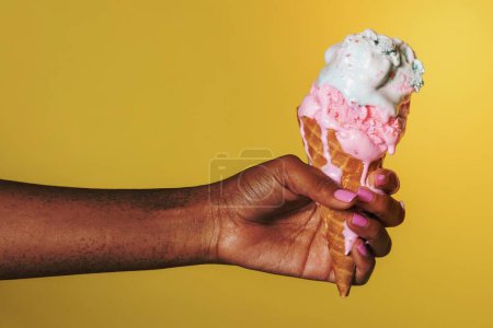 Téléchargez les photos : Main tenant une crème glacée fondante - en image libre de droit