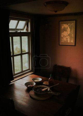 Téléchargez les photos : Repas dans la cuisine sombre près de la fenêtre - en image libre de droit