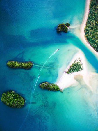 Foto de Una toma aérea de dos lanchas a motor que viajan en aguas claras entre pequeñas islas tropicales. - Imagen libre de derechos