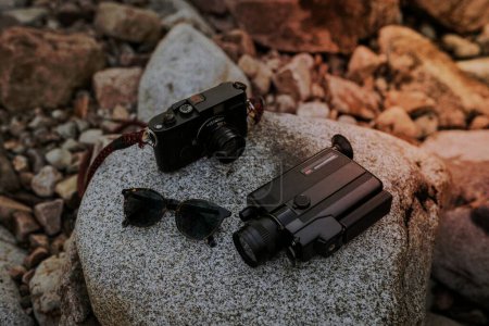 Photo for Hipster starter kit, analog cameras and vintage sunglasses on a rock - Royalty Free Image