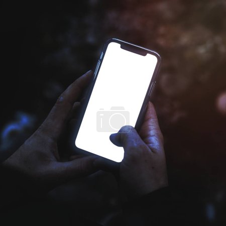 Photo for Hands holding a smartphone outdoors mockup - Royalty Free Image