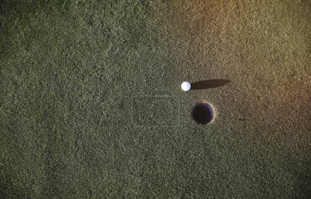 Golf ball near the hole on a putting green