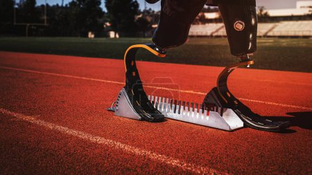 Téléchargez les photos : Athlète avec jambes prothétiques sur le bloc de départ du sprint - en image libre de droit