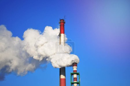 Téléchargez les photos : Stacks de fumée contre le ciel bleu - en image libre de droit