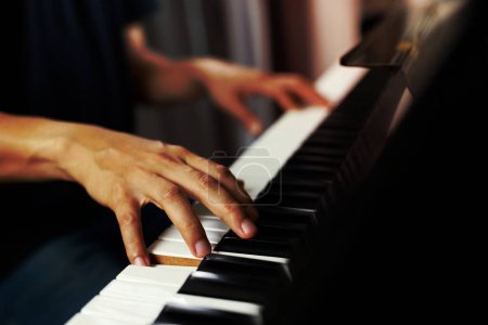 Téléchargez les photos : Close up of hand people man musician playing piano keyboard with selective focus keys. can be used as a background. - en image libre de droit