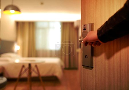Photo for Person Holding on Door Lever Inside Room - Royalty Free Image