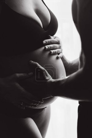 Photo for Pregnancy photo session at home, in the kitchen, in the room on the bed, by the window and in the bathroom, brushing your teeth, putting your hands on your tummy and making cheesecakes from flour - Royalty Free Image